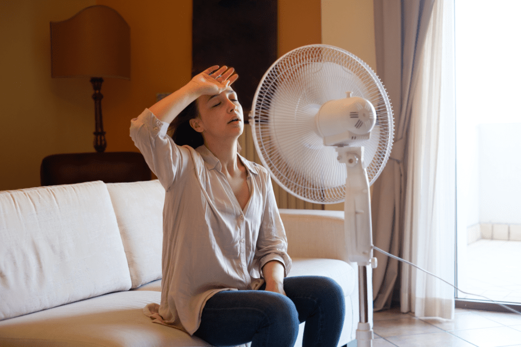 Girl sitting in front of fan because of broken AC